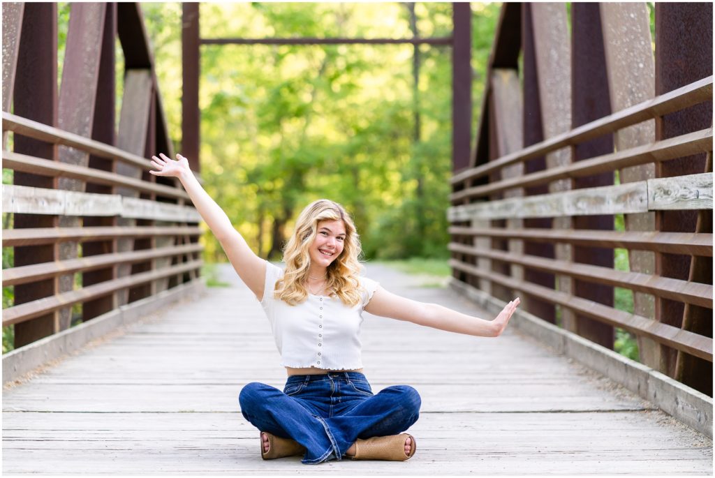 senior girl poses on a bridge at Grindstone Nature Area in Columbia Missouri for her senior portrait session with West Plains Missouri Wedding and Senior Portrait photographer, Hannah Carr Photography.