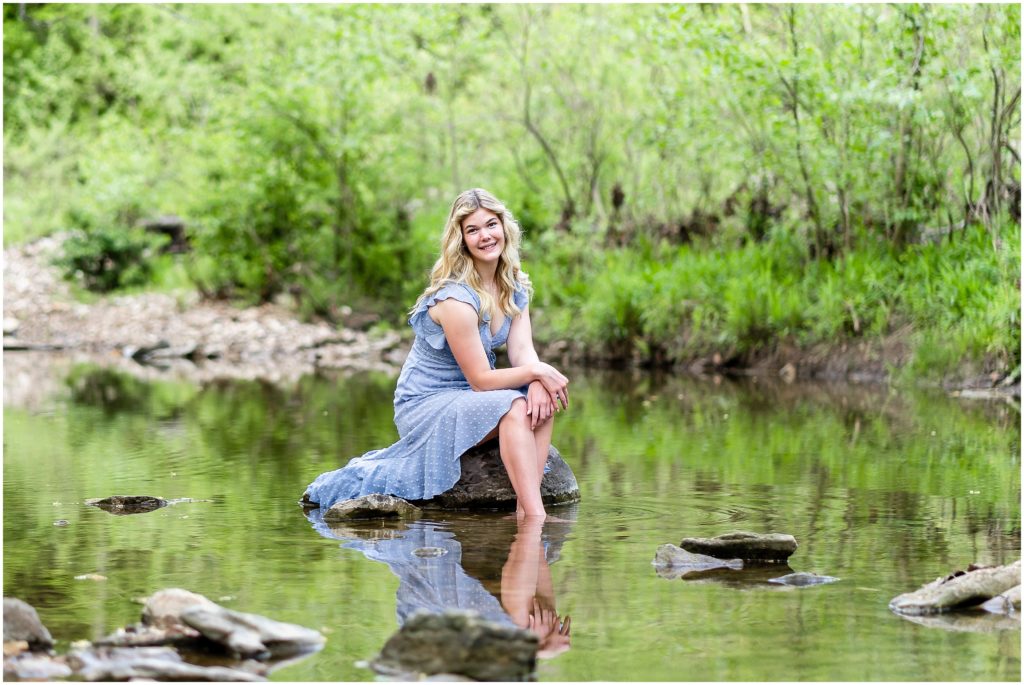  senior girl poses on a rock in a creek at Grindstone Nature Area in Columbia Missouri for her senior portrait session with West Plains Missouri Wedding and Senior Portrait photographer, Hannah Carr Photography.