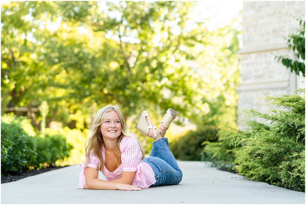 Senior girl lays down on her stomach on a sidewalk at Mizzou for senior pictures in Columbia, Missouri by West Plains, Missouri photographer, Hannah Carr Photography