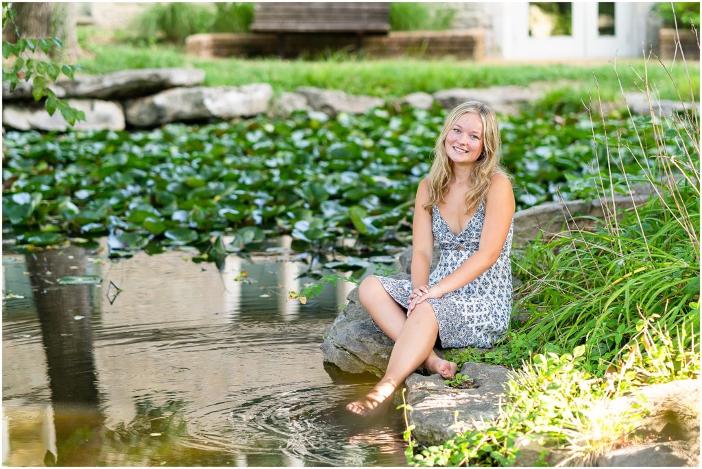 Senior girl poses by a koi pond for her senior pictures at Mizzou in Columbia, Missouri by West Plains, Missouri photographer, Hannah Carr Photography