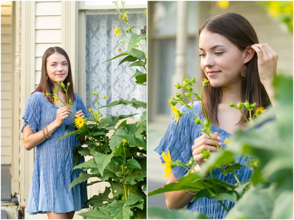 Senior girl poses in a flower bush by an old house at Nifong Park in Columbia, MO for her senior portrait session with West Plains, MO photographer, Hannah Carr Photography
