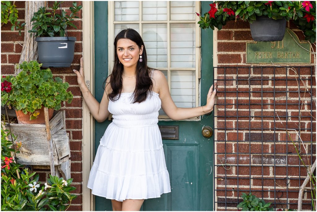 Senior girl poses by a flower shop door in Columbia Missouri for her senior session with West Plains Photographer, Hannah Carr Photography.