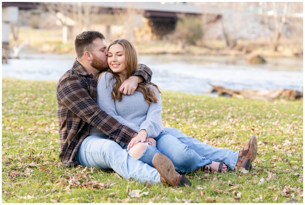 An engaged couple poses by the lake at Mammoth Spring State Park for their engagement session with Hannah Carr Photography.