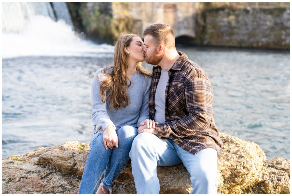 An engaged couple poses by the damat Mammoth Spring State Park for their engagement session with Hannah Carr Photography.