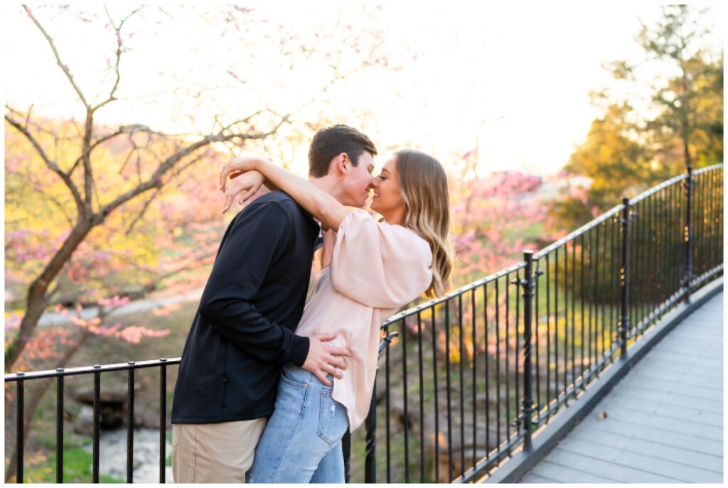 An engaged couple kiss on a bridge for their engagement session with Hannah Carr Photography, an Arkansas photographer located in Ash Flat, Arkansas