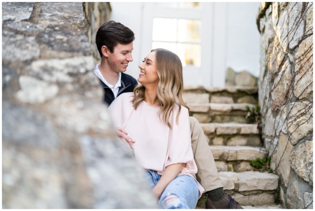An engaged couple poses on a stone stairwell at Big Cedar Lodge for their spring engagement session with Hannah Carr Photography, an Arkansas photographer located in Ash Flat, Arkansas
