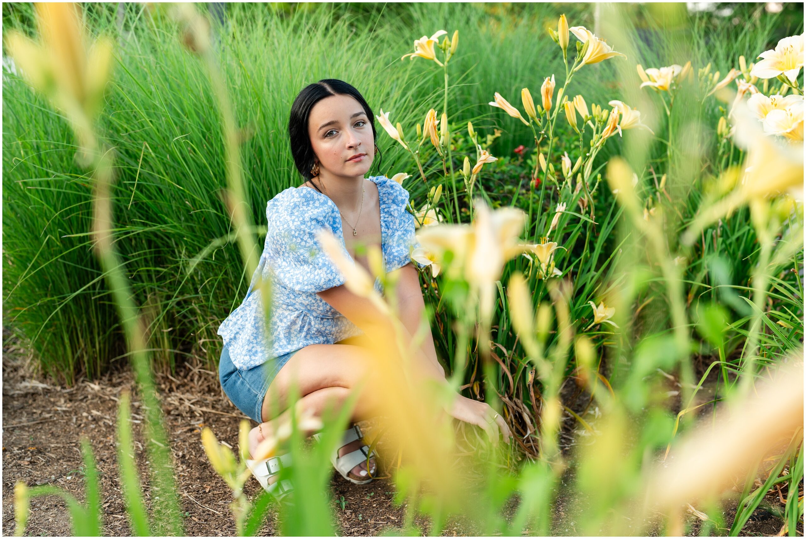 Highland High School senior, Dacy-Lynn, poses with tall grass and flowers in beautiful Cherokee Village, AR for her senior session with North Arkansas Senior Photographer, Hannah Carr Photography.